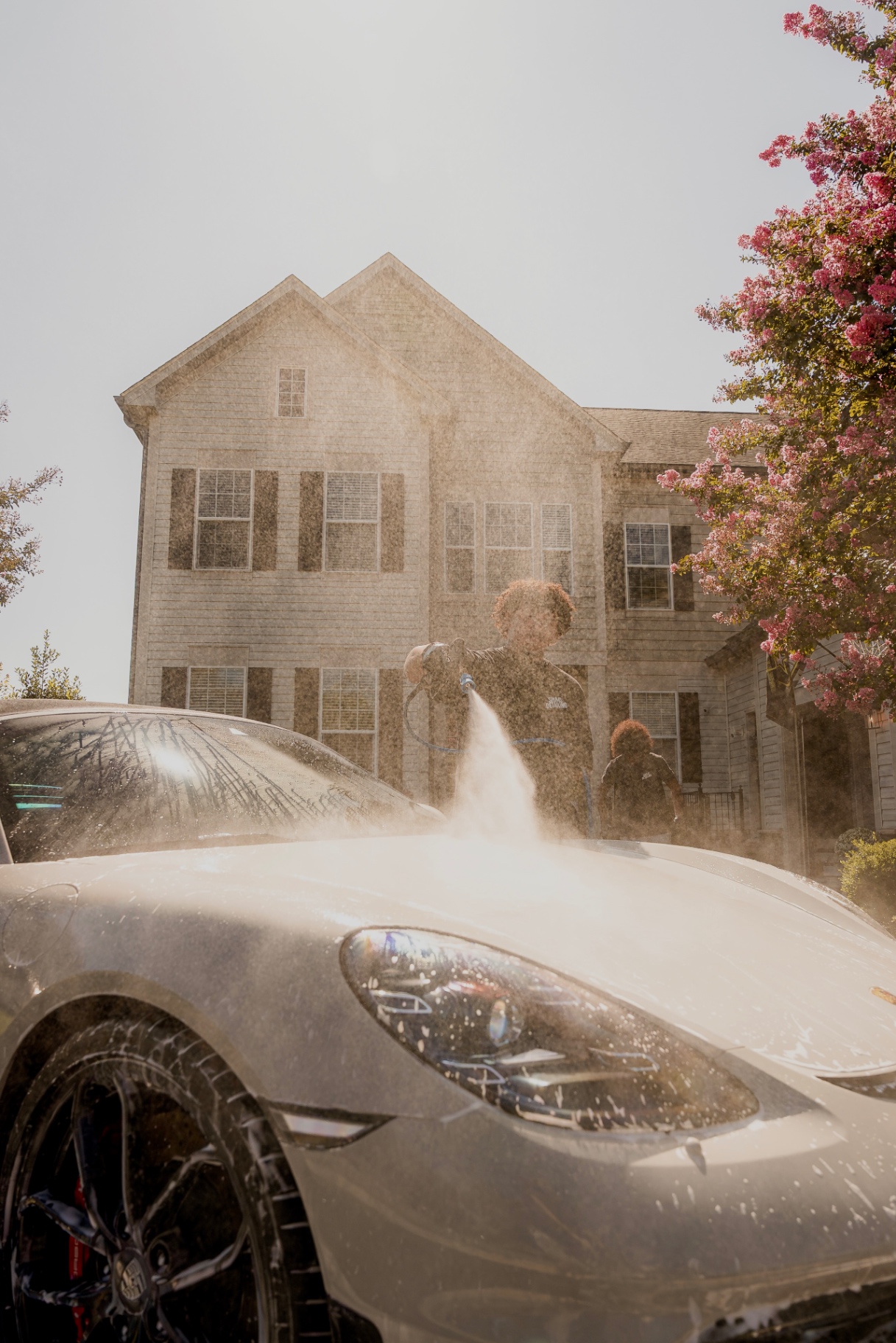 Spot-free water spraying over a sports car during a mobile exterior detail