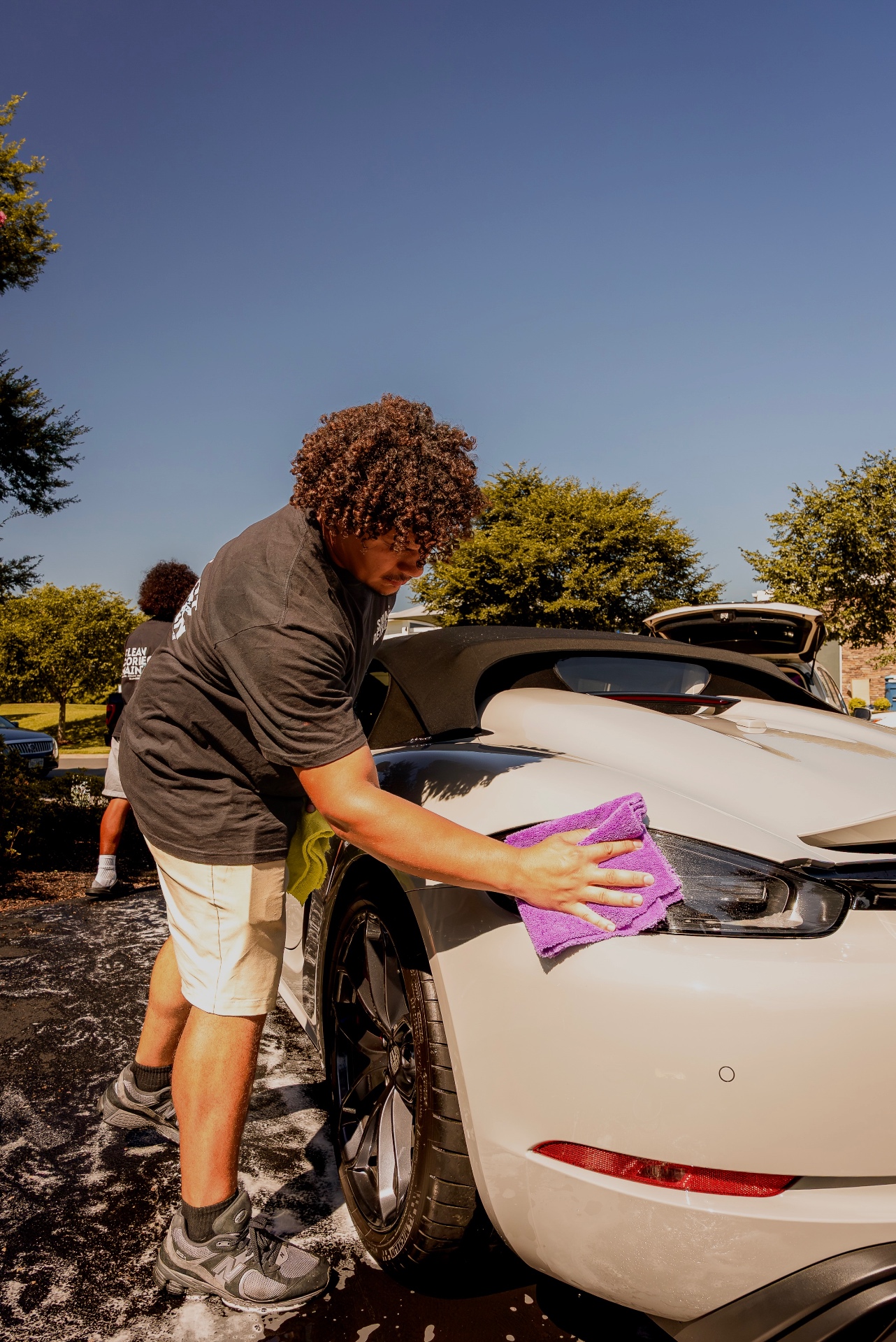 Hand-wiping paint and lights with a plush microfiber towel after an exterior detail