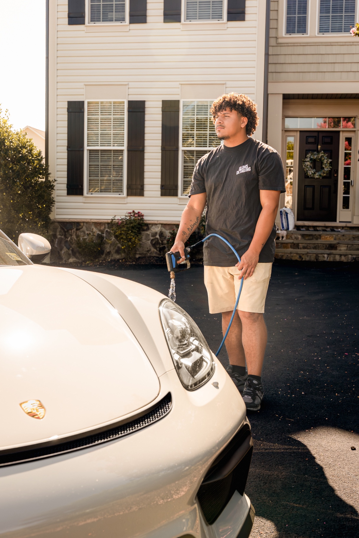 Owner Dominick rinsing the front of a Porsche with spot-free water during a mobile detail in Hagerstown, MD