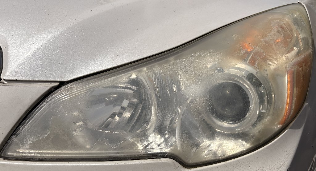 Reference photo of a damaged headlight with heavy oxidation and pitting