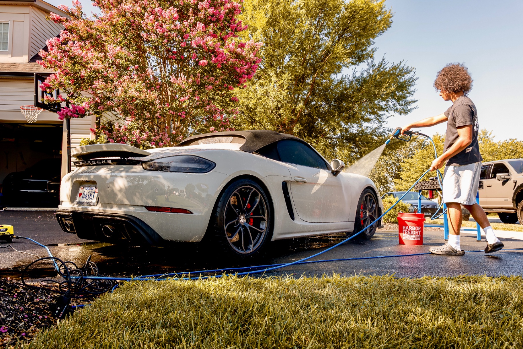 Rinsing a chalk-white Porsche Boxster with spot-free water during a mobile exterior detail